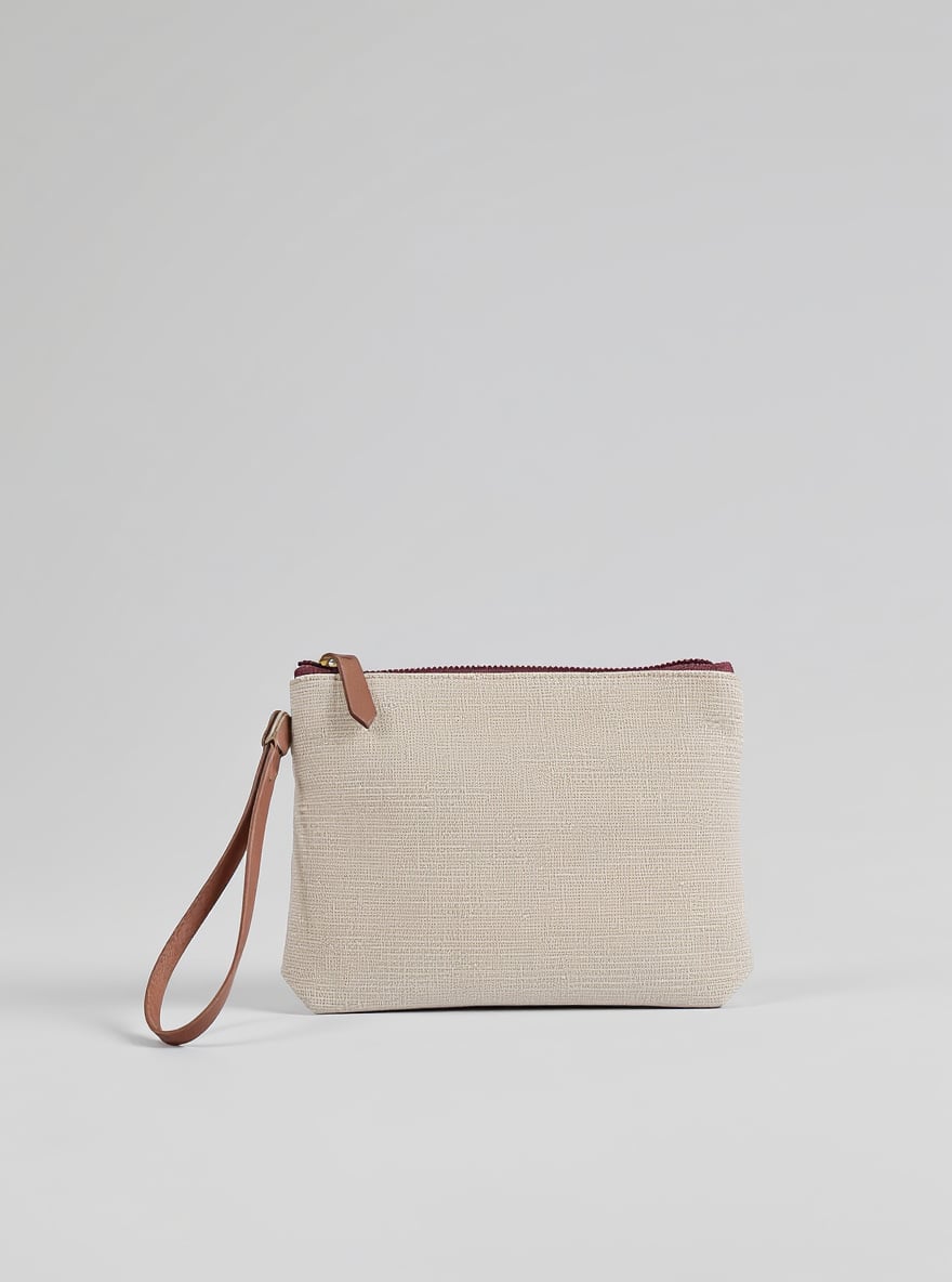 The Cream Strap Wristlet on a plain backdrop: natural linen with a slim leather wrist strap.