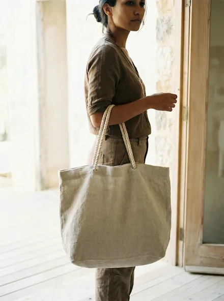 The Linen Market Tote standing upright: washed natural linen with cotton rope handles and an open top.