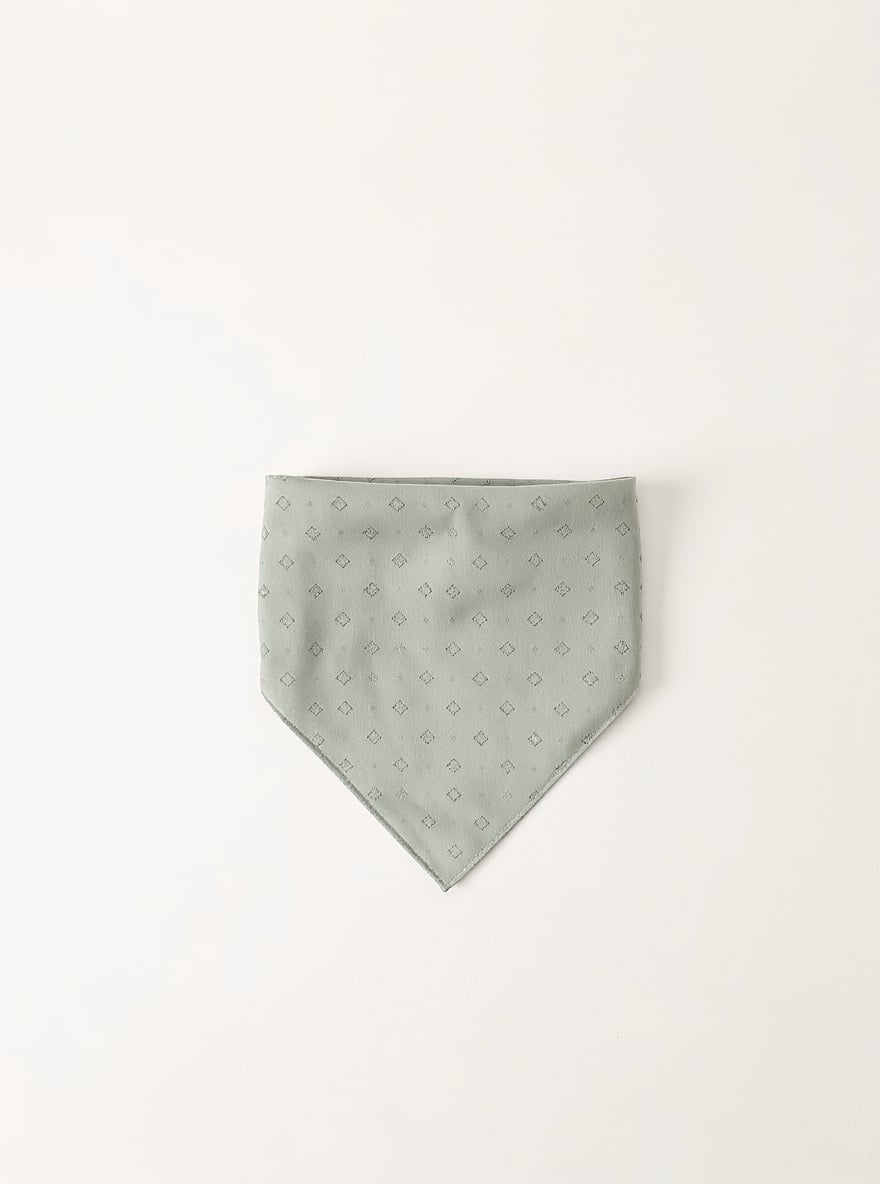 The Sage Geometric Bandana folded flat: sage washed cotton with a geometric block print.
