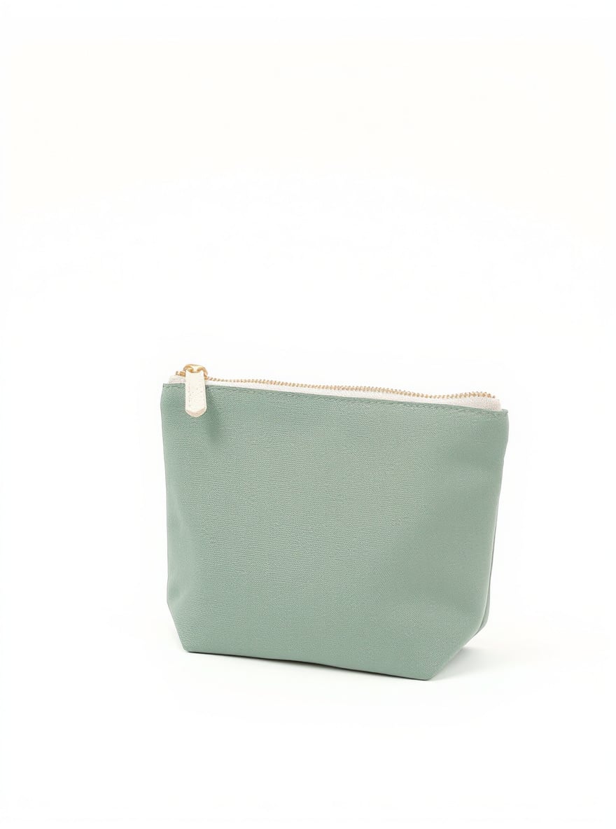 The Sage Zip Pouch on a plain backdrop: washed sage canvas with a contrast cream zip.